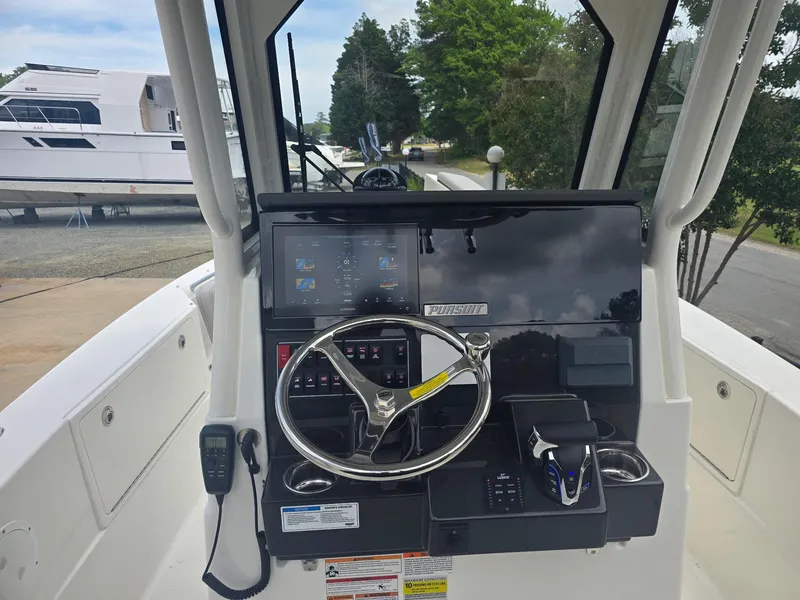 Slide: The Image of 2025 Pursuit S 248 Sport boat dashboard with steering wheel and control panel. - 5