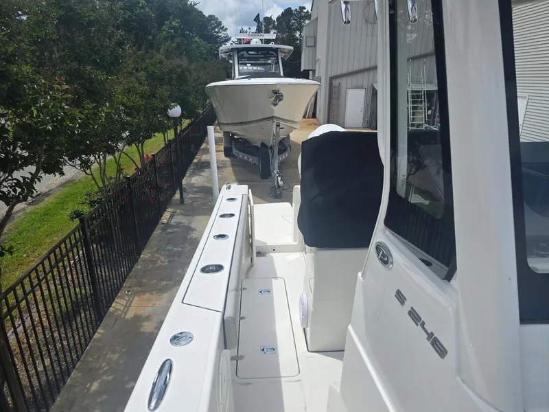 Slide: The Image of 2025 Pursuit S 248 Sport boat parked outdoors near a building. - 7