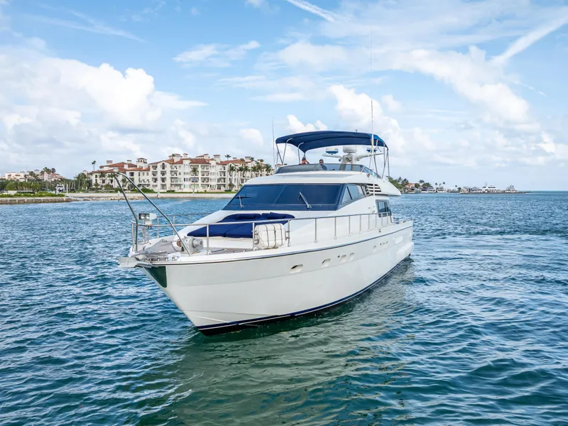 The Image of Sanlorenzo 62 yacht from 1995 cruising on a sunny day near coastal buildings. - 1