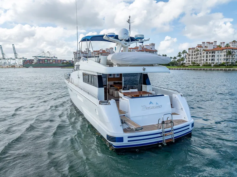 Slide: The Image of Sanlorenzo 62 yacht from 1995 cruising in a scenic harbor with buildings in the background. - 13