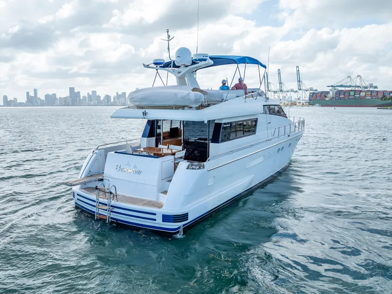 Slide: The Image of Sanlorenzo 62 yacht from 1995 cruising near a city skyline and port. - 14