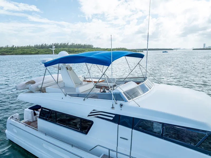 Slide: The Image of Sanlorenzo 62 yacht, 1995 model, cruising on a serene waterway under a blue sky. - 16