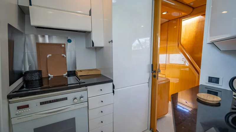 Slide: The Image of Kitchen area of a 1995 Sanlorenzo 62 yacht with modern appliances and wooden accents. - 31