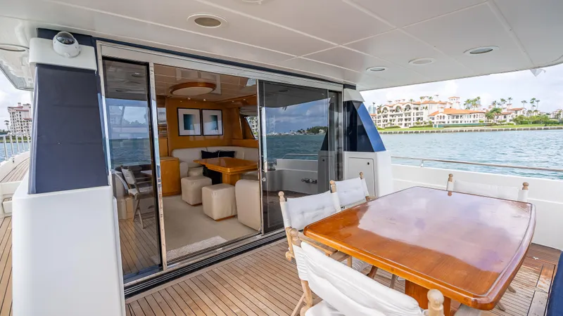 Slide: The Image of Luxurious 1995 Sanlorenzo 62 yacht with elegant outdoor dining area and scenic waterfront view. - 48