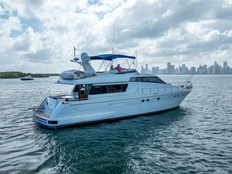 Slide: The Image of Sanlorenzo 62 yacht from 1995 cruising near a city skyline under cloudy skies. - 9