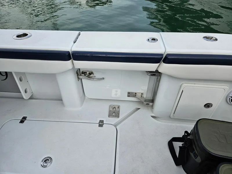 Slide: The Image of 2022 Yellowfin 39 Offshore boat interior with storage compartments and seating near water. - 11