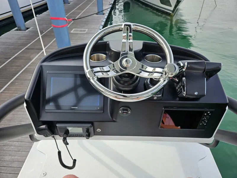 Slide: The Image of 2022 Yellowfin 39 Offshore boat helm with steering wheel and navigation display. - 12