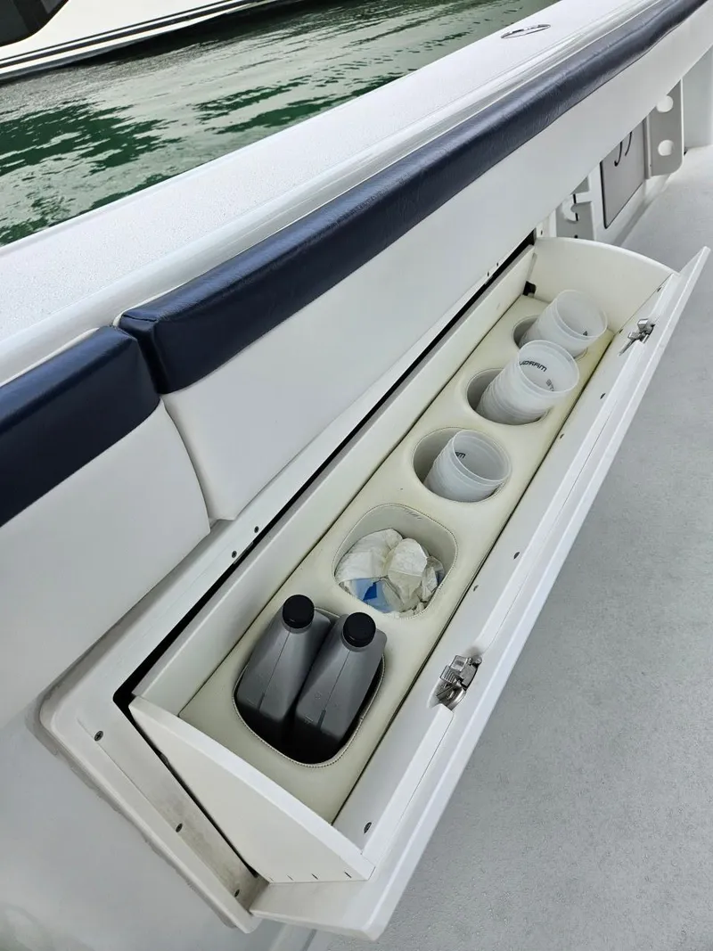 Slide: The Image of Storage compartment on 2022 Yellowfin 39 Offshore boat, featuring organized bottle holders. - 17