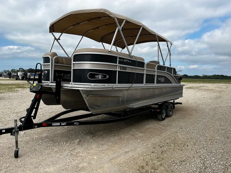 Slide: The Image of 2016 SunCatcher Elite 324 RS pontoon boat on a trailer, parked on gravel. - 3