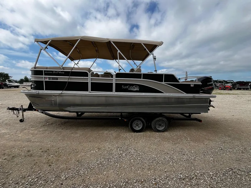 Slide: The Image of 2016 SunCatcher Elite 324 RS pontoon boat on trailer under cloudy sky. - 4