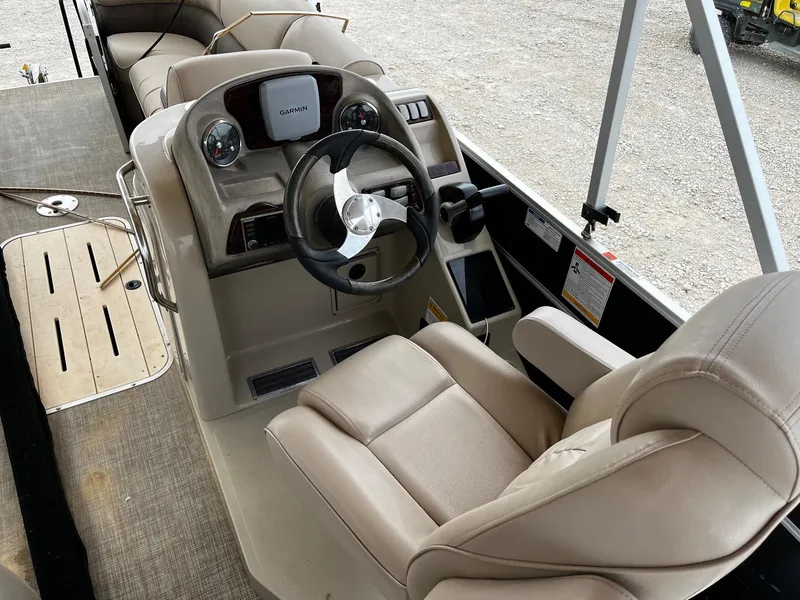 Slide: The Image of 2016 SunCatcher Elite 324 RS boat interior with beige seating and steering console. - 9