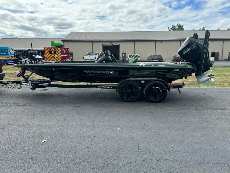 Slide: The Image of 2021 Phoenix 920 Elite boat on trailer, parked outdoors near industrial buildings. - 1
