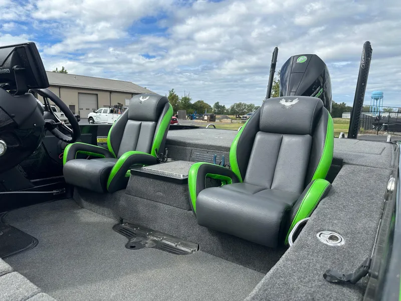 Slide: The Image of 2021 Phoenix 920 Elite boat interior with gray and green seats, under a cloudy sky. - 12