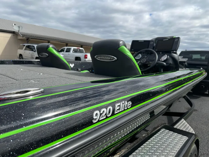 Slide: The Image of 2021 Phoenix 920 Elite boat with sleek design and green accents, parked outdoors. - 14