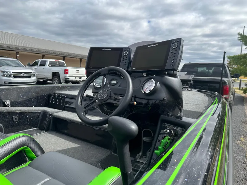 Slide: The Image of 2021 Phoenix 920 Elite boat cockpit with dual monitors and steering wheel, parked outdoors. - 15
