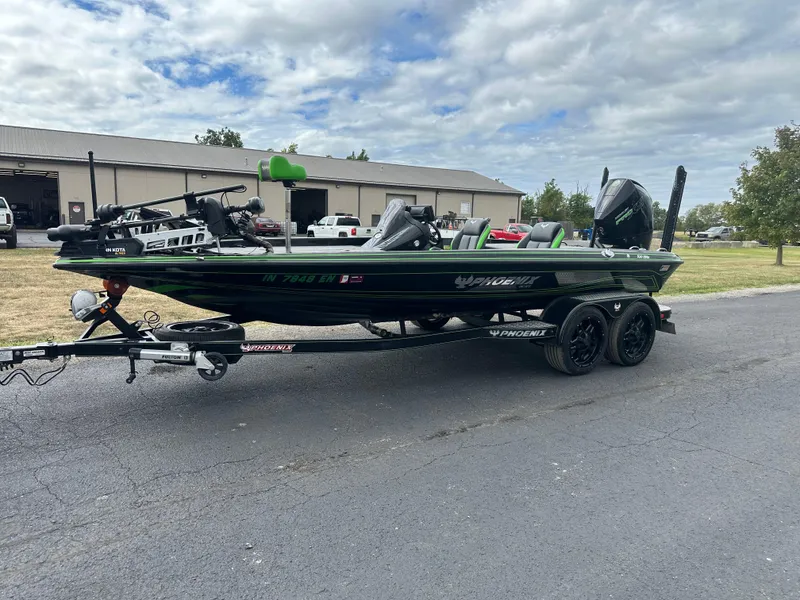 Slide: The Image of 2021 Phoenix 920 Elite boat on trailer, parked outdoors near a warehouse. - 2