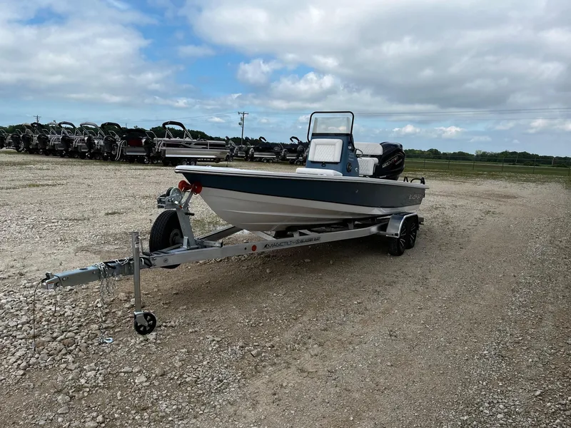 Slide: The Image of 2025 Blazer Bay 2220 Fisherman boat on trailer in gravel lot under cloudy sky. - 4