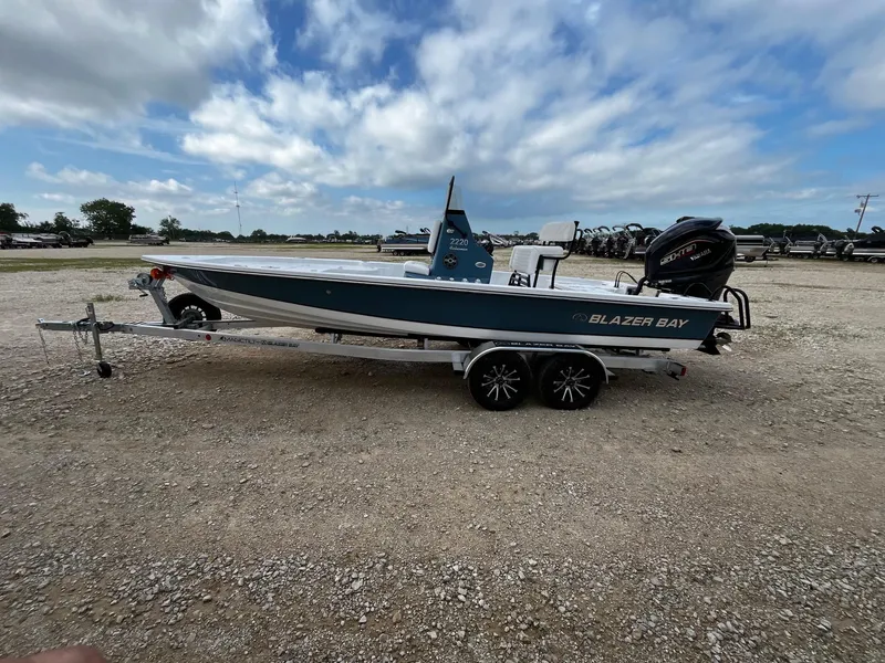 Slide: The Image of 2025 Blazer Bay 2220 Fisherman boat on trailer under cloudy sky. - 5