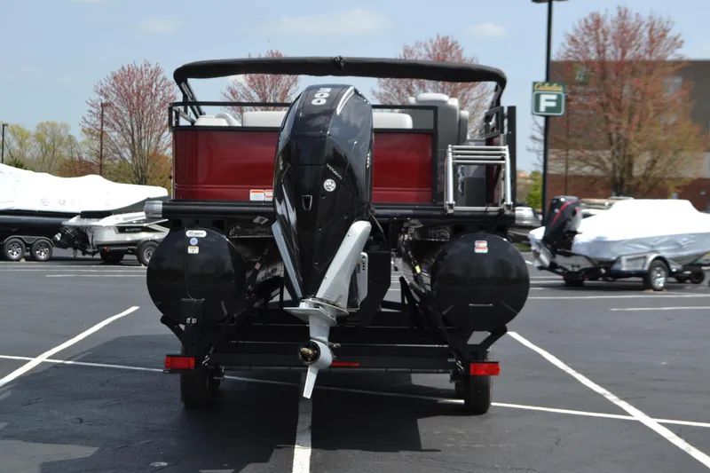 Slide: The Image of 2022 Regency 250DL3 pontoon boat with outboard motor in parking lot. - 2