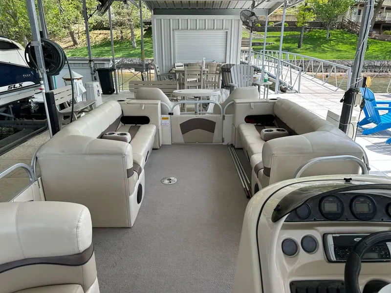 Slide: The Image of 2004 PlayCraft 2500 Ultra pontoon boat interior with beige seating and control panel. - 11