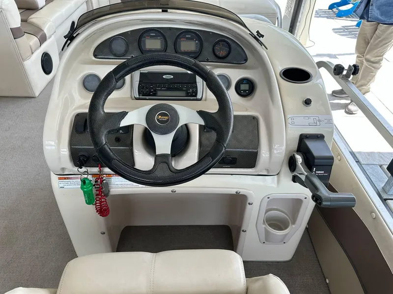 Slide: The Image of 2004 PlayCraft 2500 Ultra boat dashboard with steering wheel and control panel. - 14