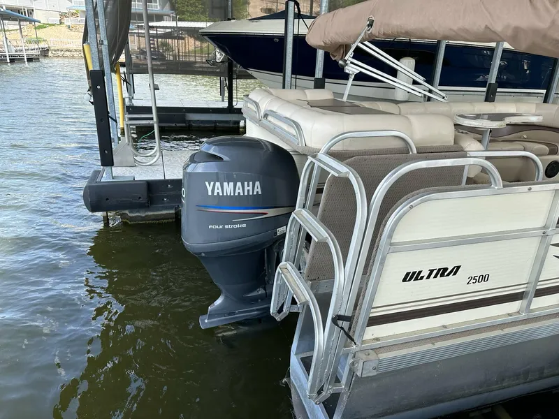 Slide: The Image of 2004 PlayCraft 2500 Ultra pontoon boat with Yamaha outboard motor docked on water. - 2