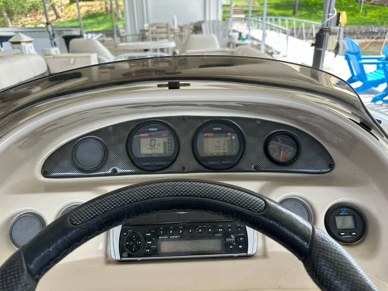 Slide: The Image of 2004 PlayCraft 2500 Ultra dashboard with gauges and steering wheel in a marina setting. - 22