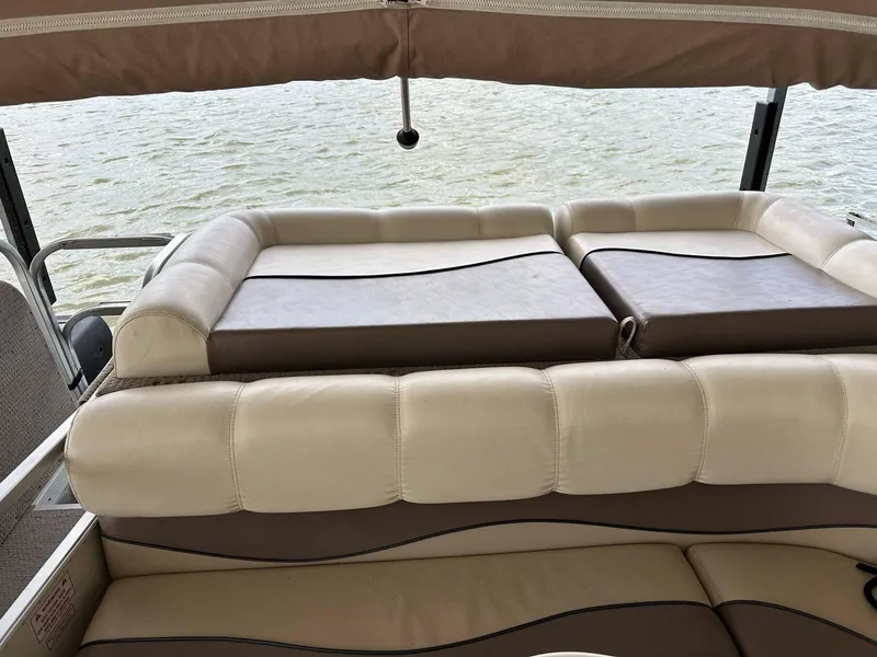 Slide: The Image of 2004 PlayCraft 2500 Ultra boat interior with beige seating, overlooking water. - 3