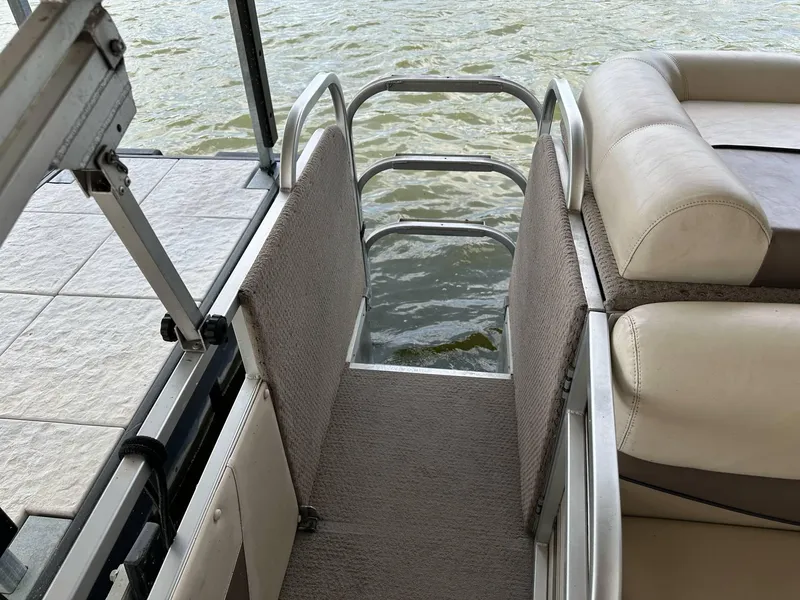 Slide: The Image of 2004 PlayCraft 2500 Ultra boat with cushioned seating and water access ladder. - 30