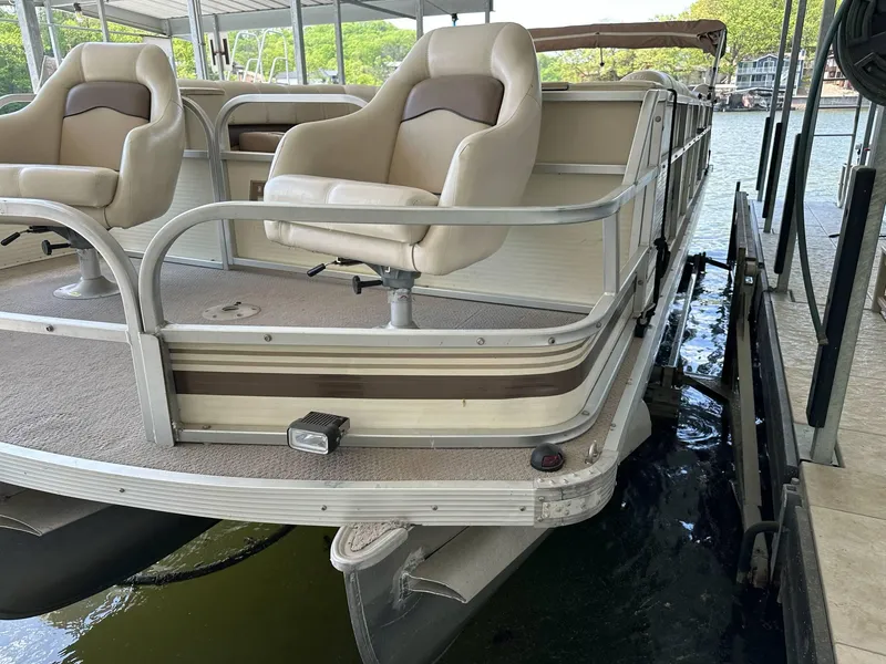 Slide: The Image of 2004 PlayCraft 2500 Ultra pontoon boat docked, featuring comfortable seating and sturdy railings. - 37