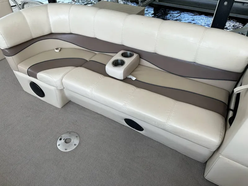 Slide: The Image of 2004 PlayCraft 2500 Ultra boat seating with beige and brown upholstery, featuring built-in cup holders. - 4