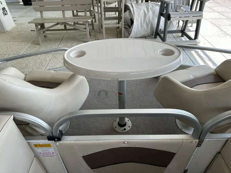 Slide: The Image of 2004 PlayCraft 2500 Ultra boat interior with seating and table, featuring cup holders. - 6