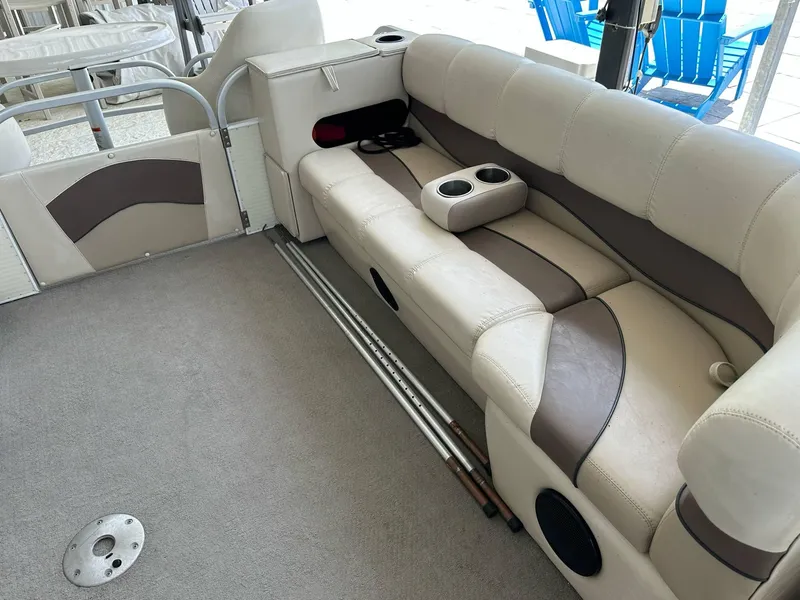 Slide: The Image of 2004 PlayCraft 2500 Ultra boat interior with beige seating and cup holders. - 8