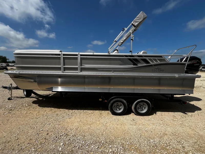 Slide: The Image of 2025 SunCatcher Select 324SL pontoon boat on a trailer under a clear blue sky. - 4