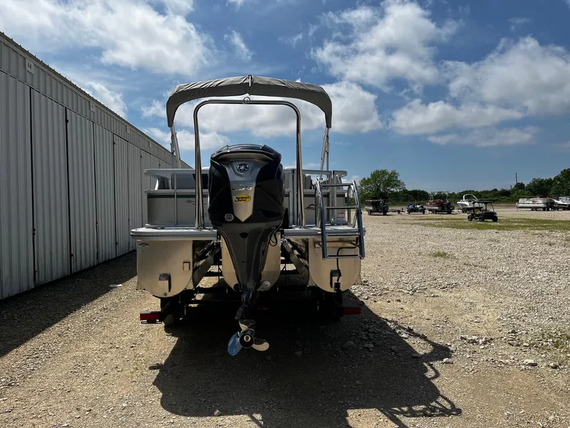 Slide: The Image of 2025 SunCatcher Select 324SL pontoon boat with outboard motor, parked outdoors. - 6
