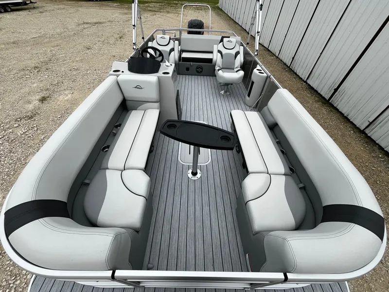 Slide: The Image of 2025 SunCatcher Select 324SL pontoon boat interior with gray seating and central table. - 8