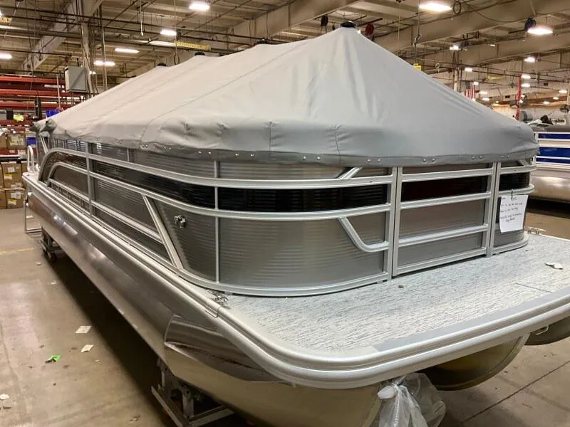 Slide: The Image of 2025 Bennington 23SSR-SPS pontoon boat with cover in a warehouse setting. - 3