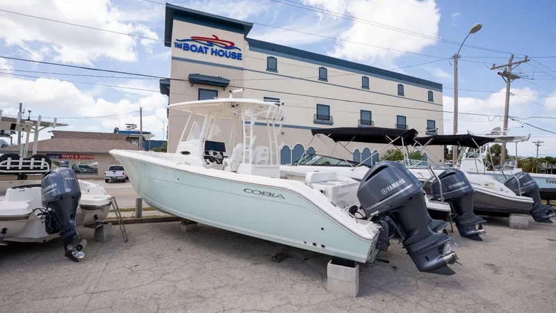 Slide: The Image of 2021 Cobia 301 CC boat displayed at The Boat House dealership. - 1