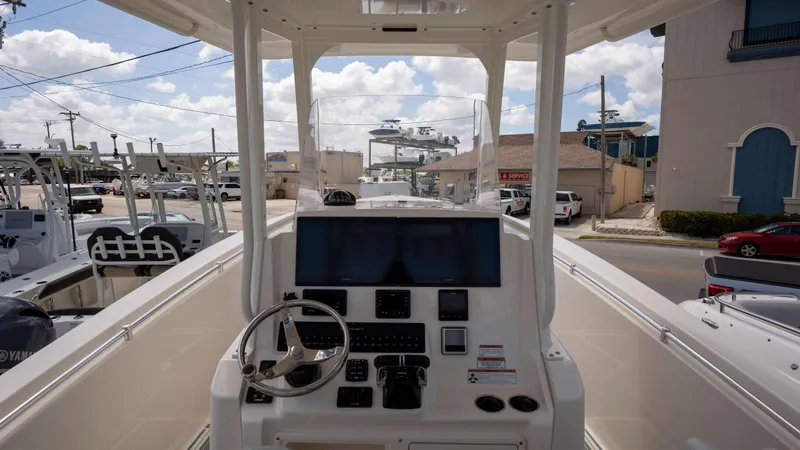 Slide: The Image of 2021 Cobia 301 CC boat dashboard with steering wheel and navigation screens. - 12