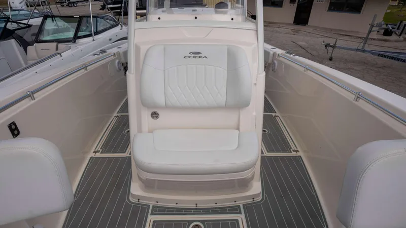 Slide: The Image of 2021 Cobia 301 CC boat interior with white seating and sleek design. - 3