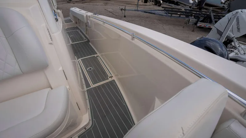 Slide: The Image of 2021 Cobia 301 CC boat interior with cushioned seating and sleek flooring. - 5