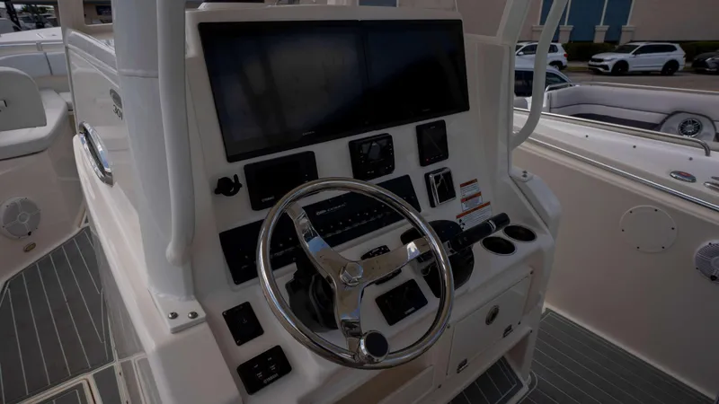Slide: The Image of 2021 Cobia 301 CC boat dashboard with steering wheel and electronic controls. - 8