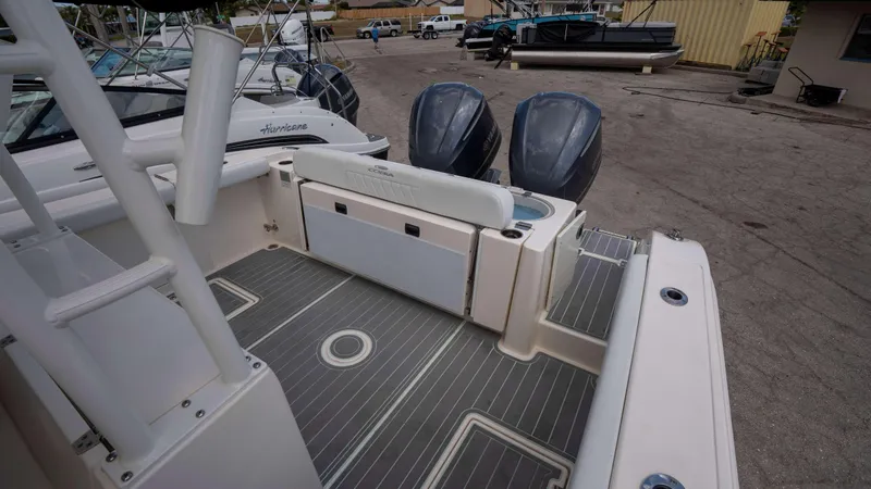Slide: The Image of 2021 Cobia 301 CC boat with dual outboard motors and spacious deck area. - 9