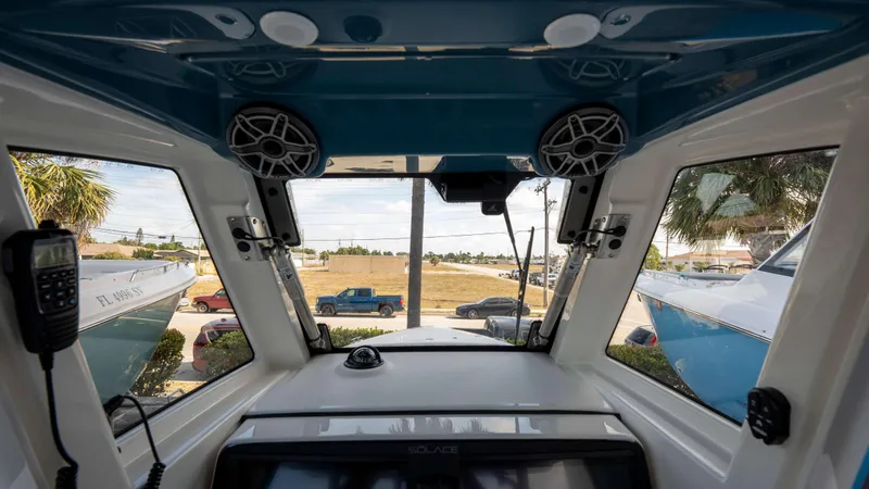 Slide: The Image of Interior view of 2025 Solace 28 HCS boat cockpit with speakers and windows. - 11
