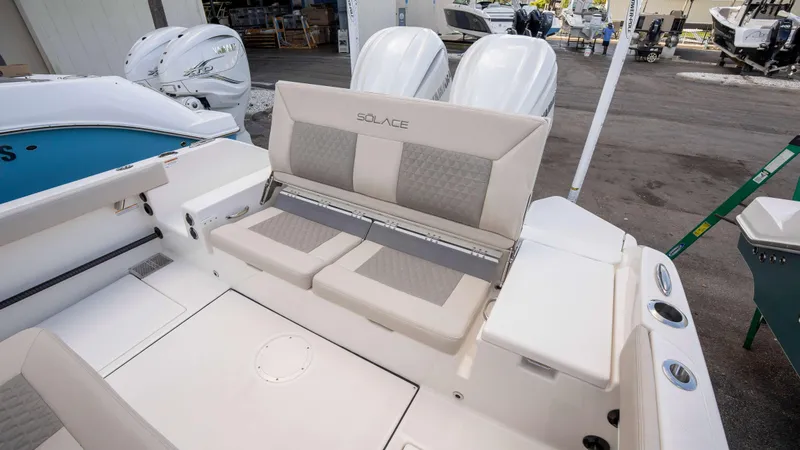 Slide: The Image of 2025 Solace 28 HCS boat interior with cushioned seating and dual outboard engines. - 14