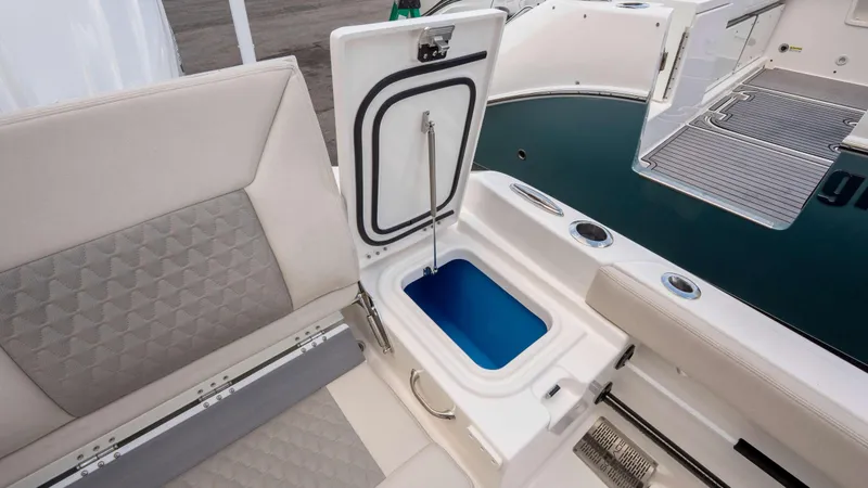 Slide: The Image of 2025 Solace 28 HCS boat interior with open storage compartment and cushioned seating. - 15