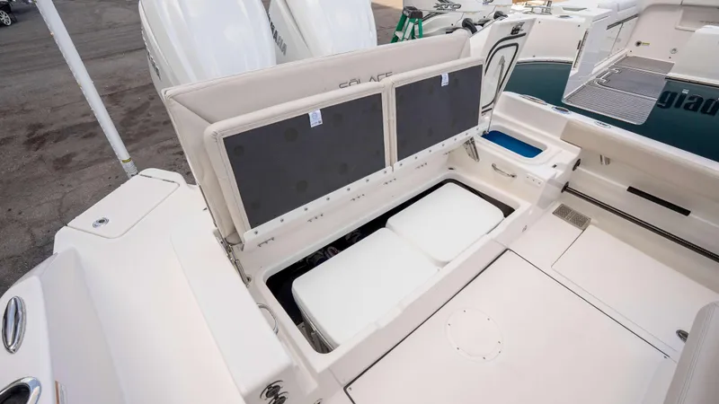 Slide: The Image of 2025 Solace 28 HCS boat with open storage compartments and dual outboard engines. - 16