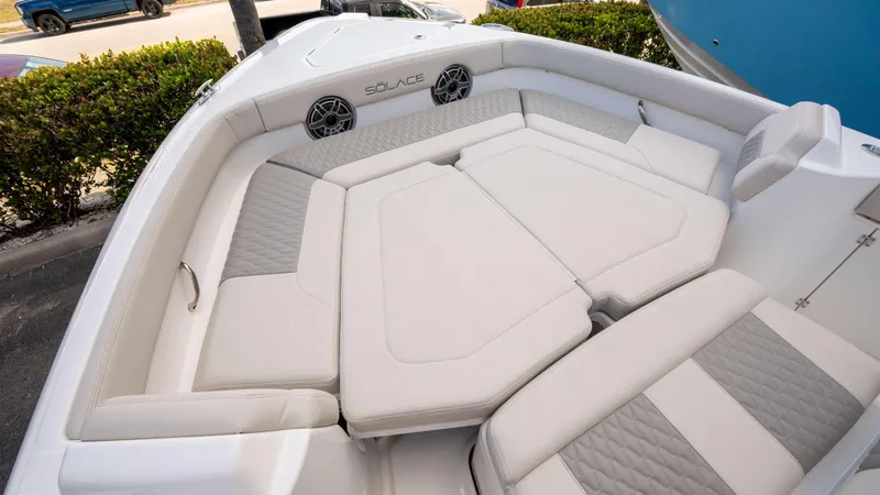 Slide: The Image of Luxurious seating area on 2025 Solace 28 HCS boat, featuring plush cushions and speakers. - 2