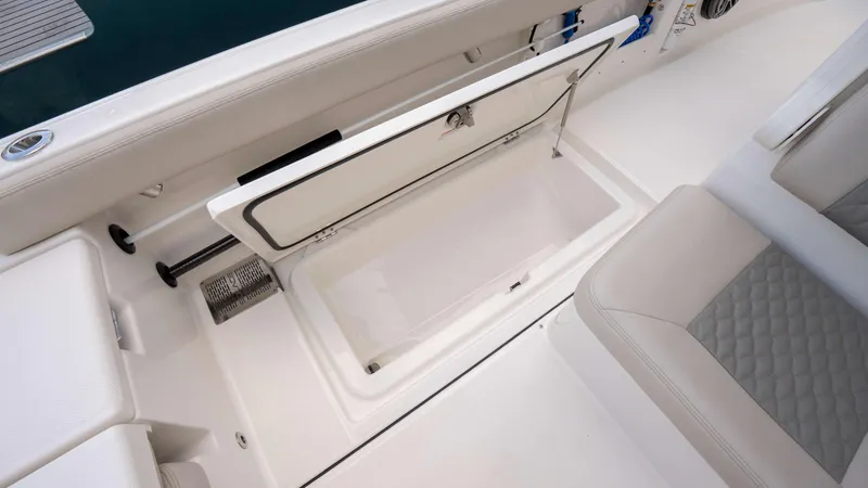 Slide: The Image of Open storage compartment on 2025 Solace 28 HCS boat, featuring sleek white interior design. - 22