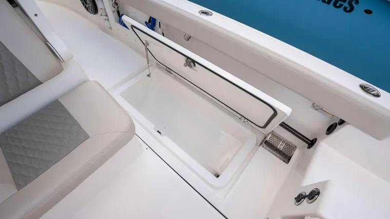 Slide: The Image of 2025 Solace 28 HCS boat interior with open storage compartment and cushioned seating. - 23